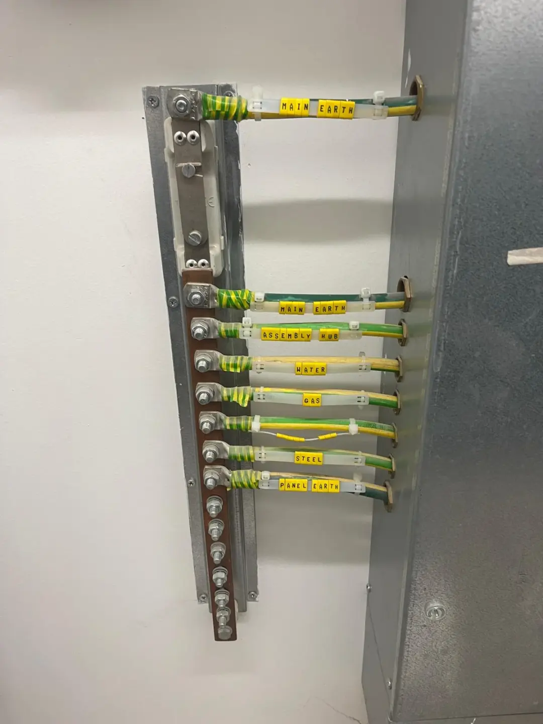 Copper earth bar with labelled green and yellow bonding conductors