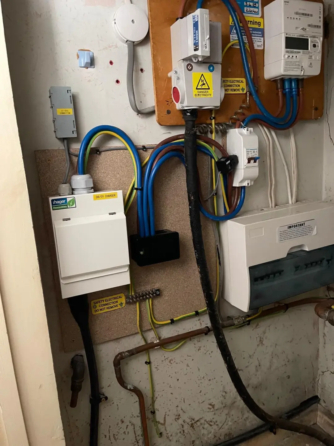 Dedicated EV charger consumer unit beside the existing electricity meter and fuse board