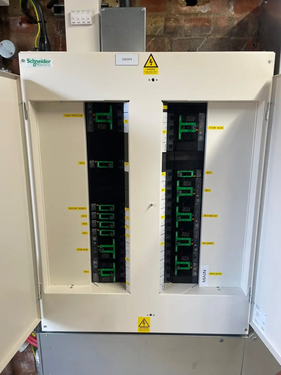 Schneider Electric distribution board with labelled circuit breakers and open cabinet doors